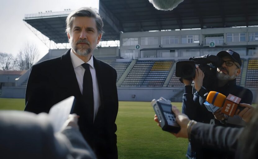 Soccer manager speaks to journalists on a stadium